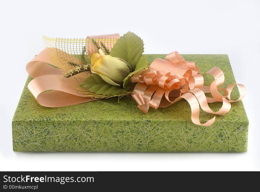 Green gift box with orange ribbon and flower isolated on white