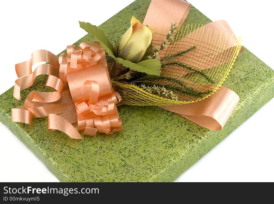 Green gift box with orange ribbon and flower isolated on white