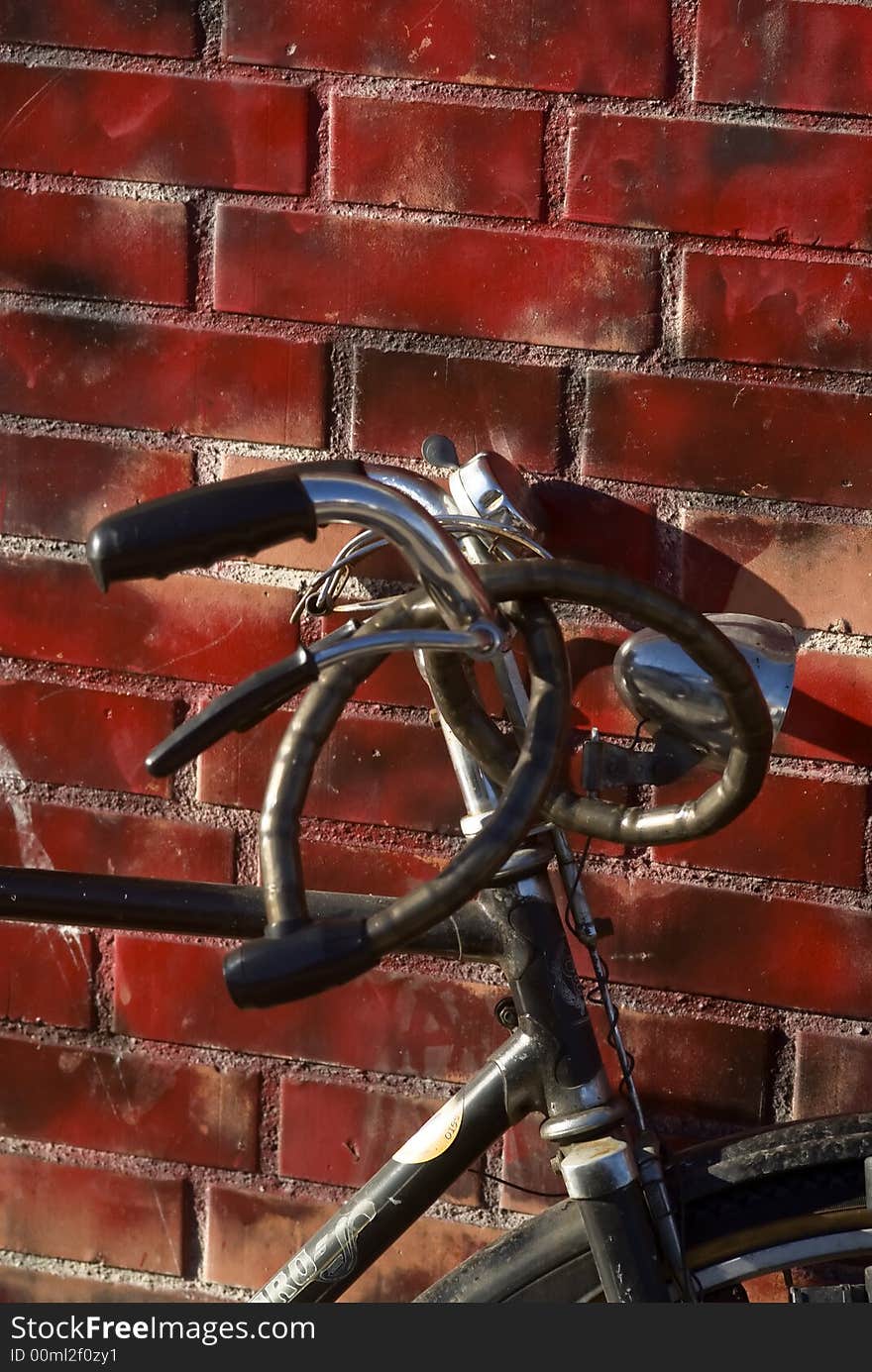 Old bike leaning up against a red wall. Old bike leaning up against a red wall