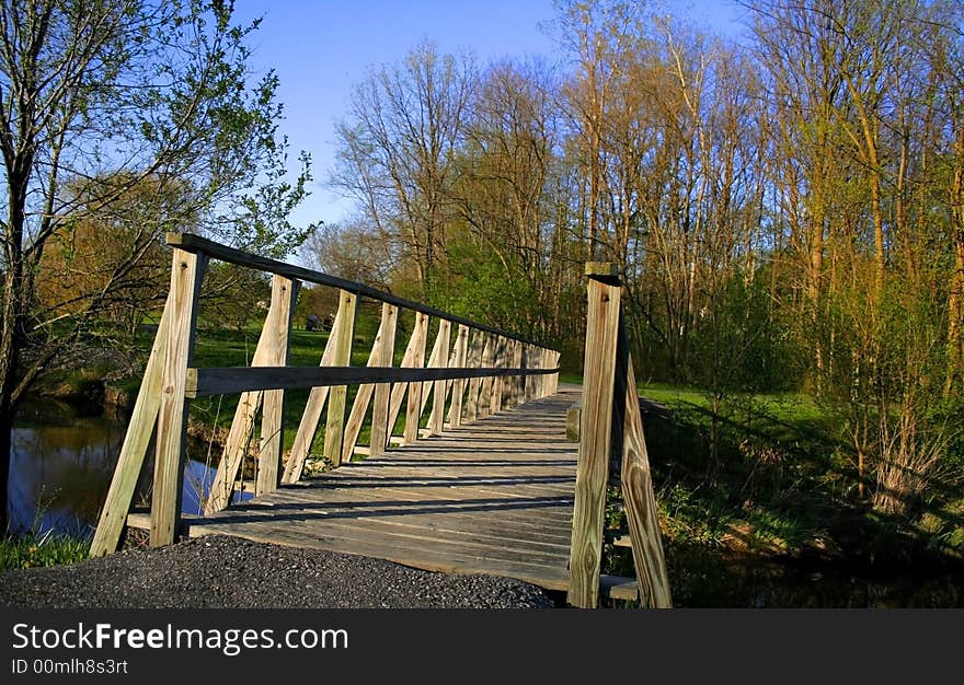 Bridge crossing a lake surrounded by trees with coloured autumn foliage. Bridge crossing a lake surrounded by trees with coloured autumn foliage