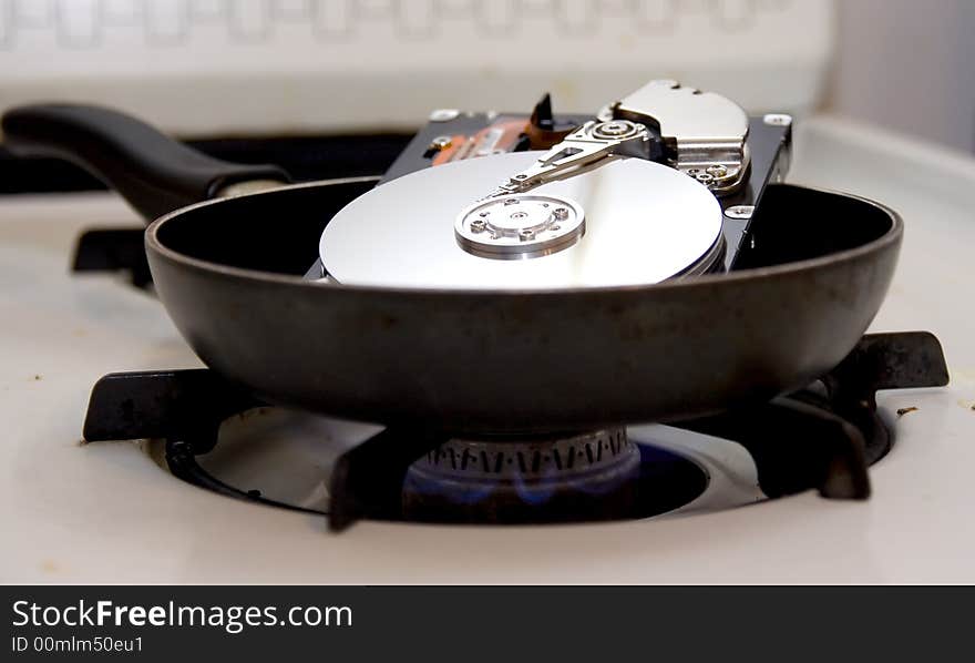 An exposed hard drive in a frying pan on a stove burner. A fried hard drive!