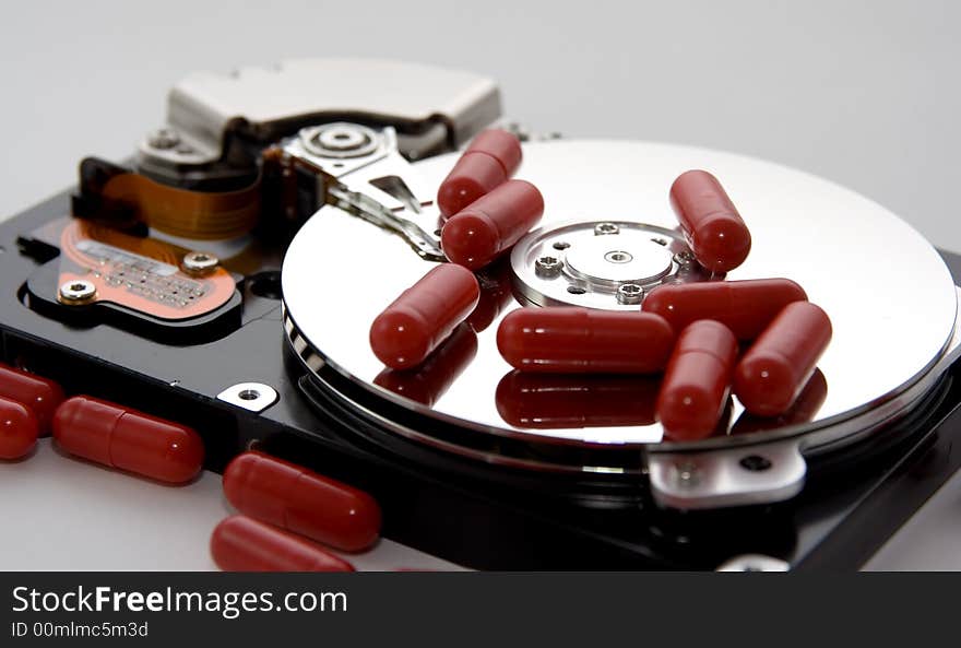 An exposed hard drive with some red capsules / pills. A remedy or fix for the drive!. An exposed hard drive with some red capsules / pills. A remedy or fix for the drive!