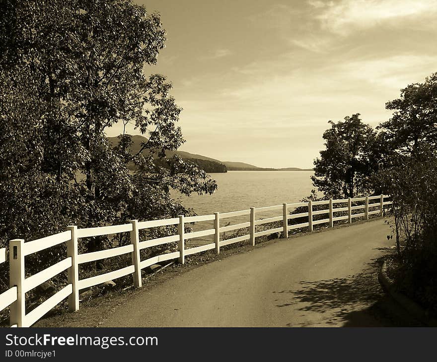 Fence on a dirt road along a lake. Fence on a dirt road along a lake