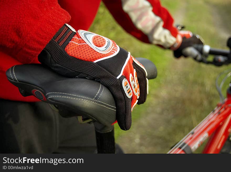 Spotrive gloves on a sportive red bike's seat. Spotrive gloves on a sportive red bike's seat