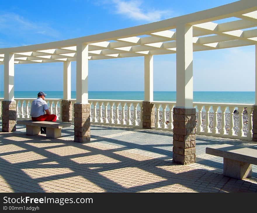 The man relaxing in snow-white summerhouse near Mediterranian sea. The man relaxing in snow-white summerhouse near Mediterranian sea