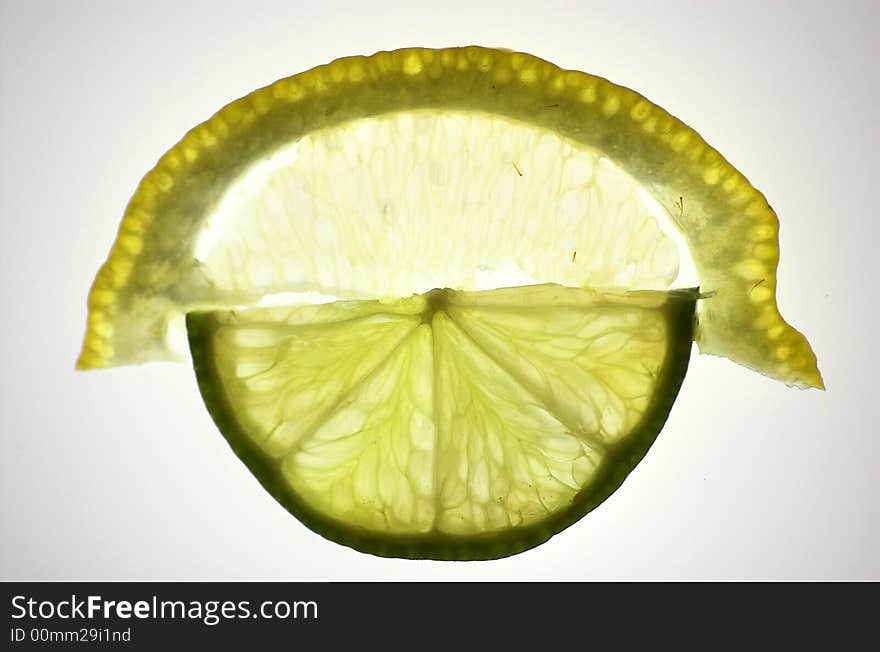 Lime and lemon slices, isolated and backlit with white backdrop, contacted