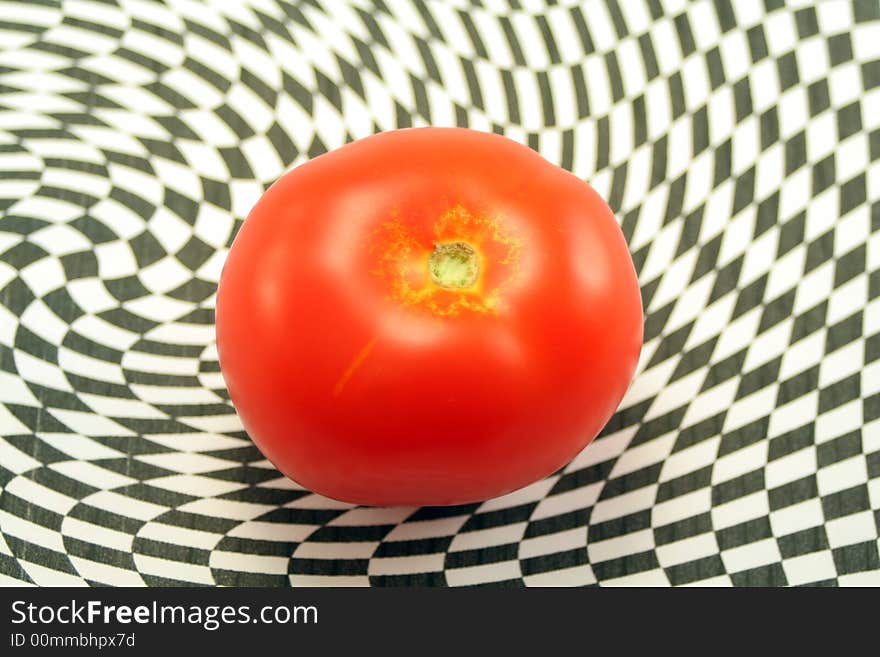 A ripe red tomato on an abstract black and white background