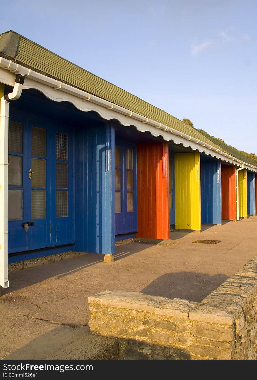 Blue, red and yellow beachhuts next to the beach promenade on Bournemouth. Blue, red and yellow beachhuts next to the beach promenade on Bournemouth