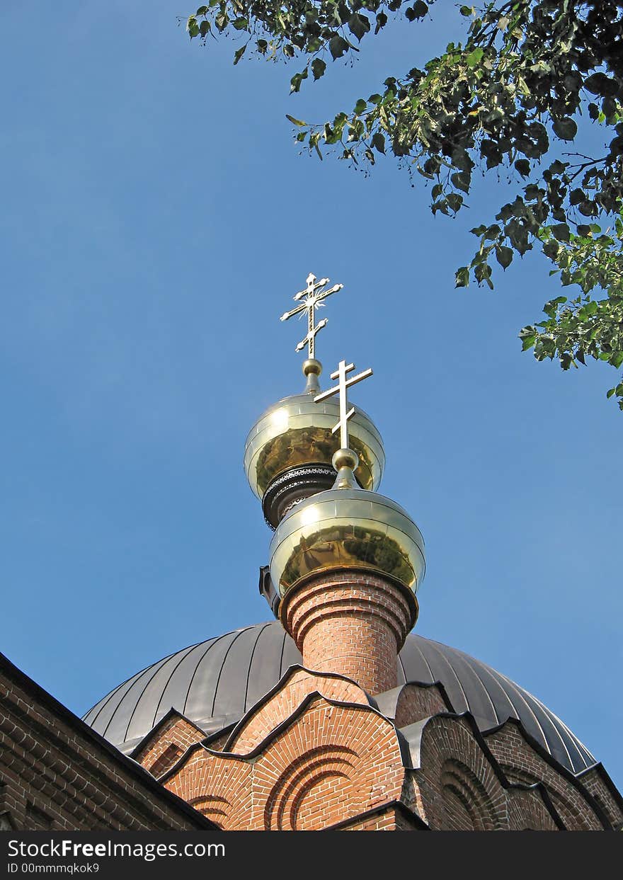 Gold crosses are photographed against the blue sky. Gold crosses are photographed against the blue sky