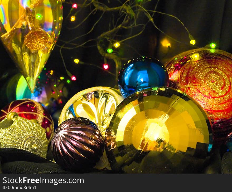 Baubles scattered on the ground on black against small twinkling LED lights. Baubles scattered on the ground on black against small twinkling LED lights