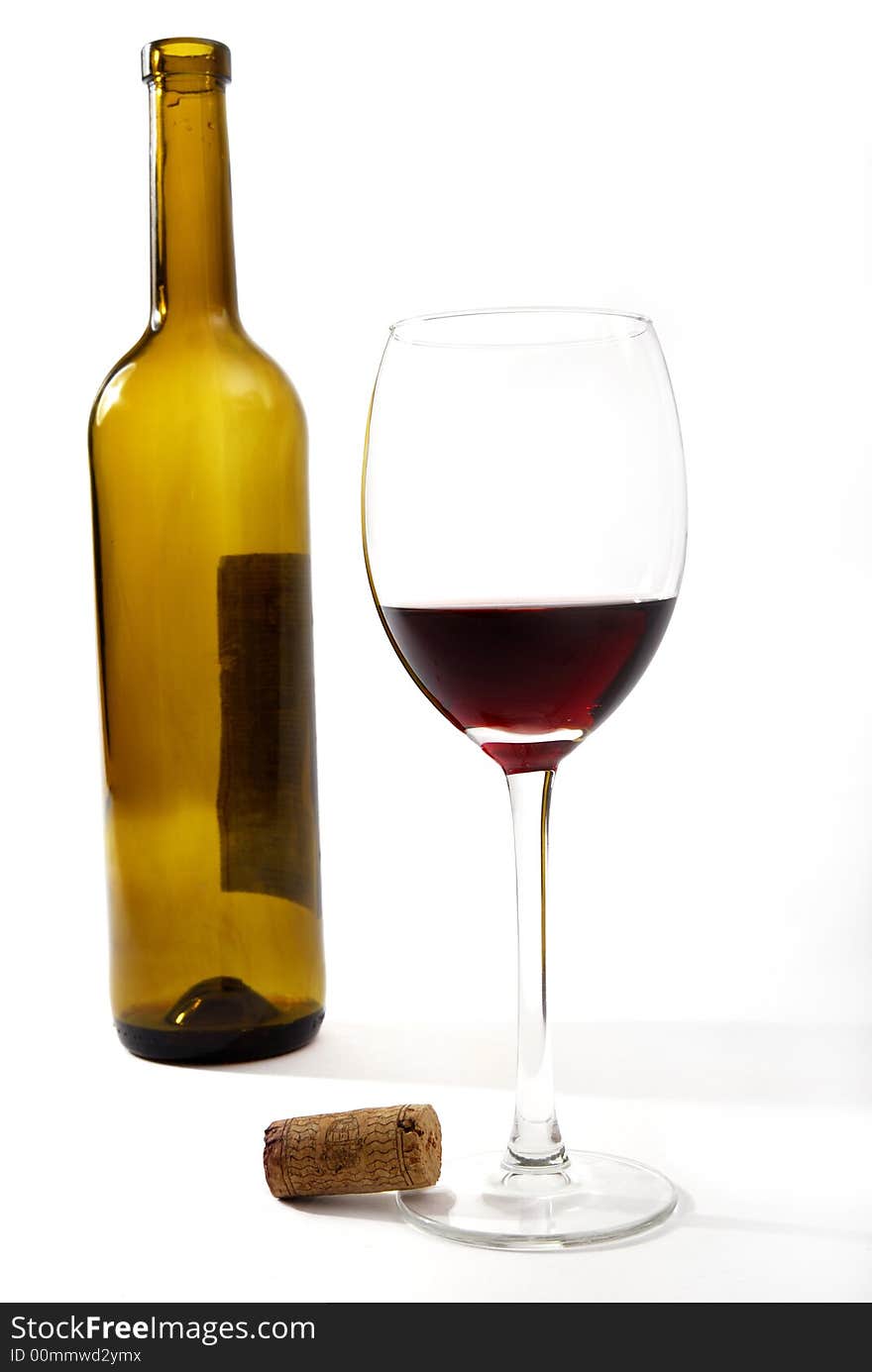 Red vine in a glass and a bottle in front of a white background