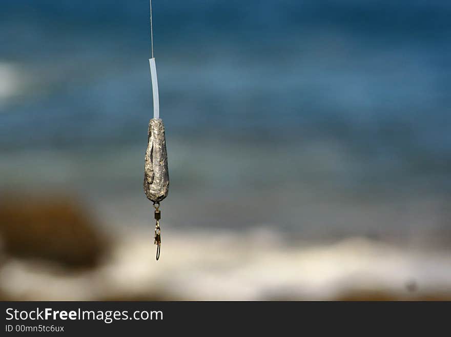 An image of a fishinh hook by the sea. An image of a fishinh hook by the sea.