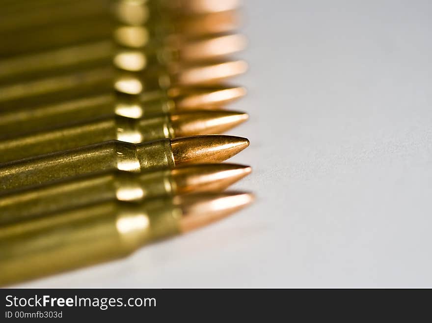 Row of rifle rounds on white sharp focus going to a nice blur. Row of rifle rounds on white sharp focus going to a nice blur