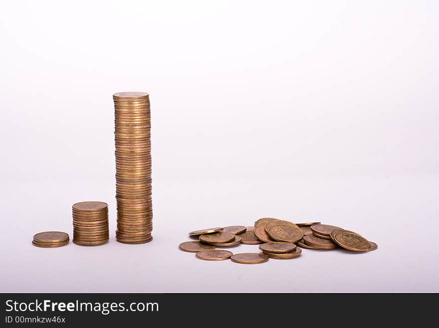 Piles of yellow coins against white background. Last one collapsed. Piles of yellow coins against white background. Last one collapsed.