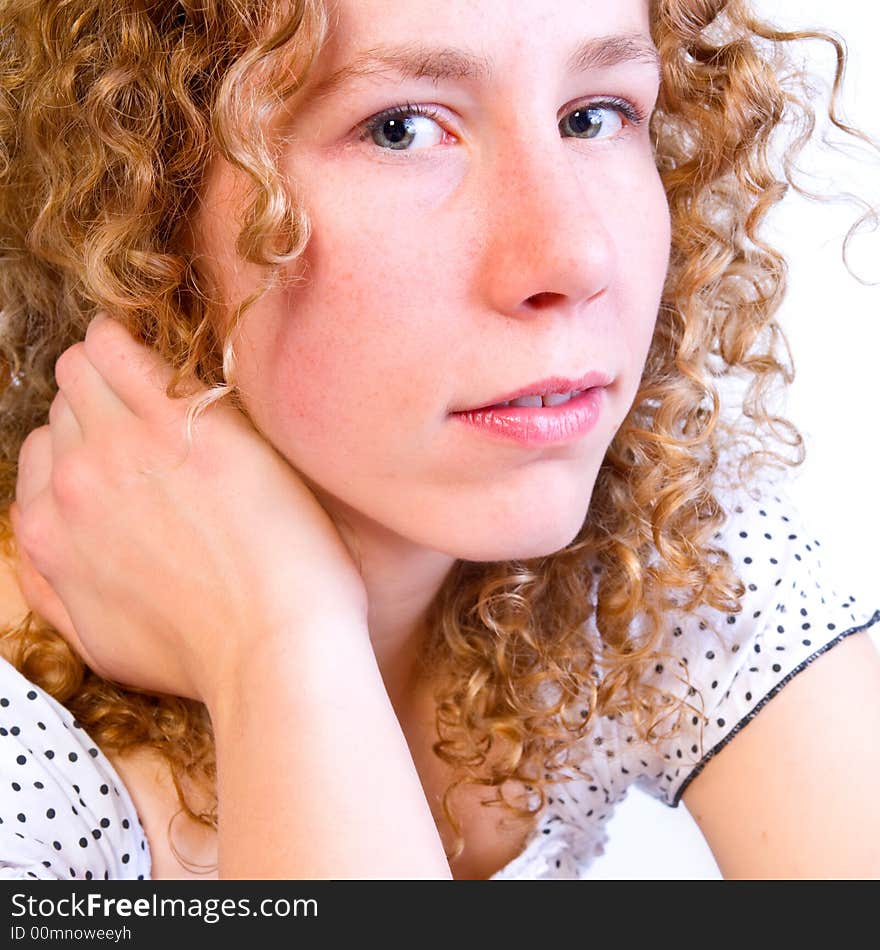 A honest portrait of a girl with curly hair in the studio