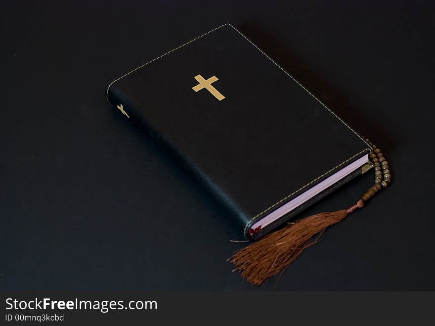 Leather bible on the ground against black background