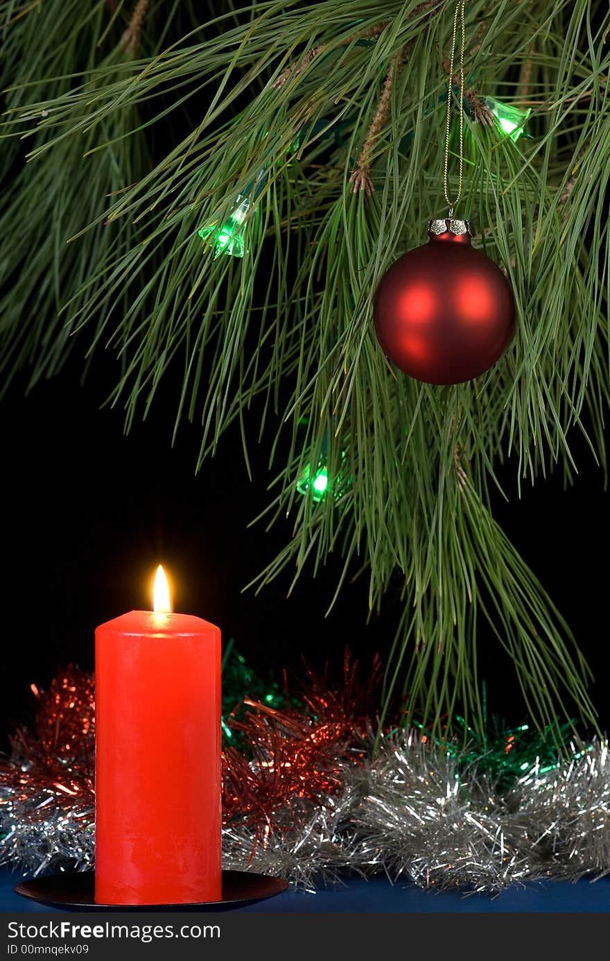 Decorated christmas tree and a lit red candle. Decorated christmas tree and a lit red candle