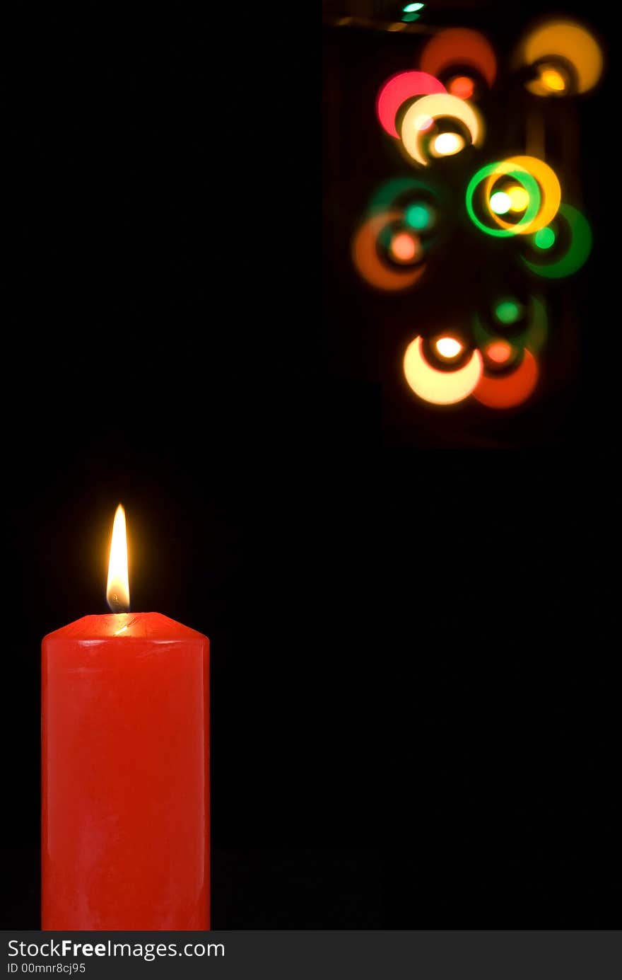 A glowing red candle with party lights. A glowing red candle with party lights