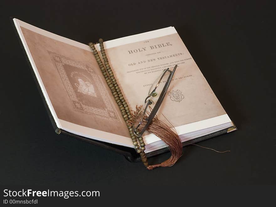 Old bible on the black background with glasses. Old bible on the black background with glasses