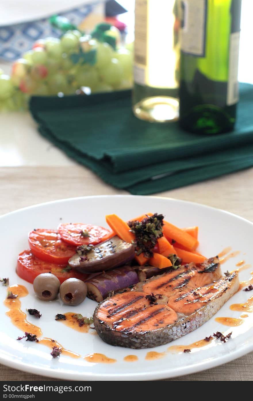 Pan seared salmon served with brinjal, carrots, sliced tomatoes and white wine