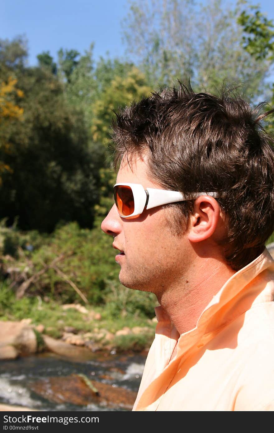 Profile of a young male model wearing white sunglasses. Profile of a young male model wearing white sunglasses