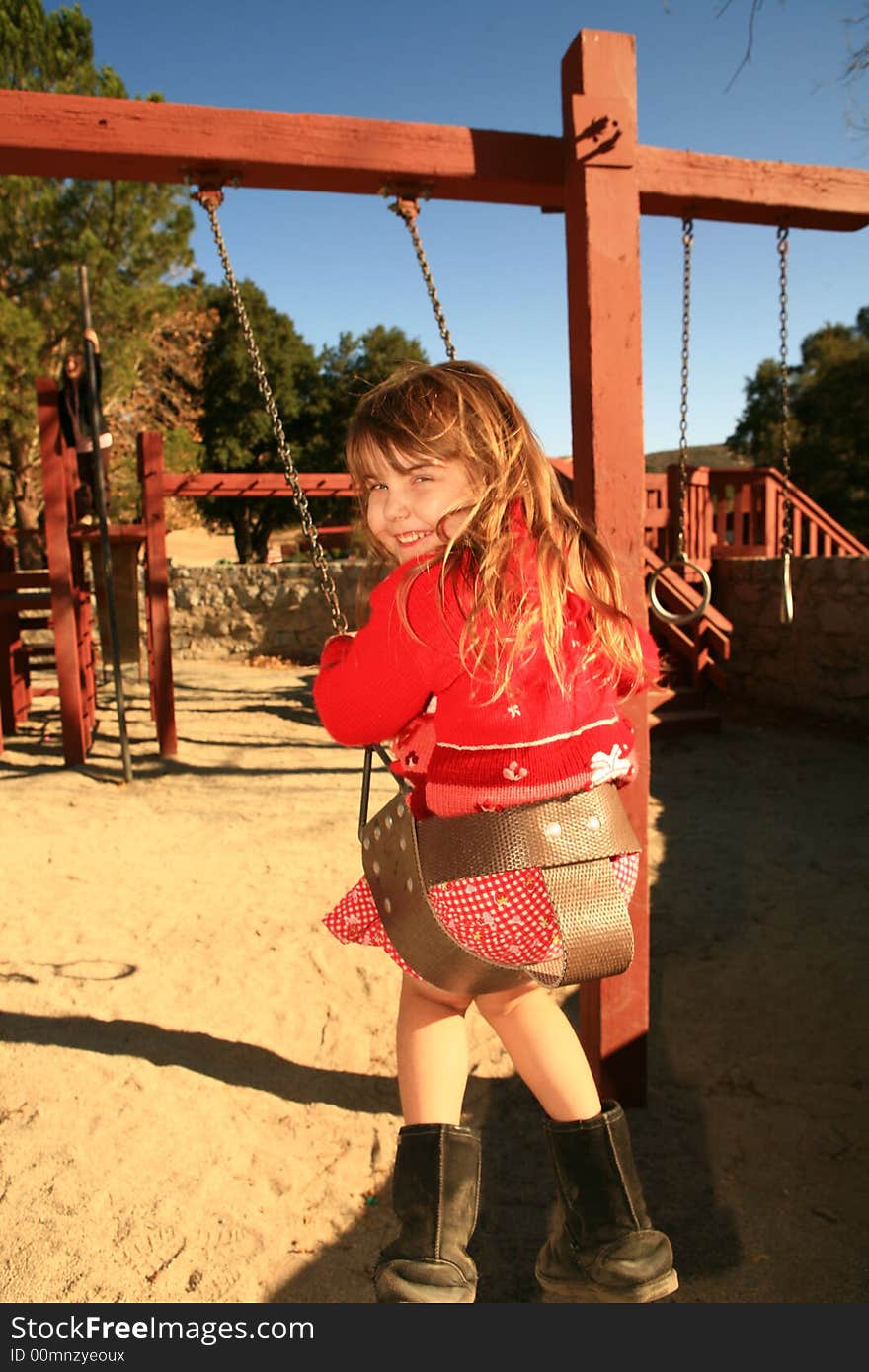 Young Child Thrilled by Swinging in the Park. Young Child Thrilled by Swinging in the Park