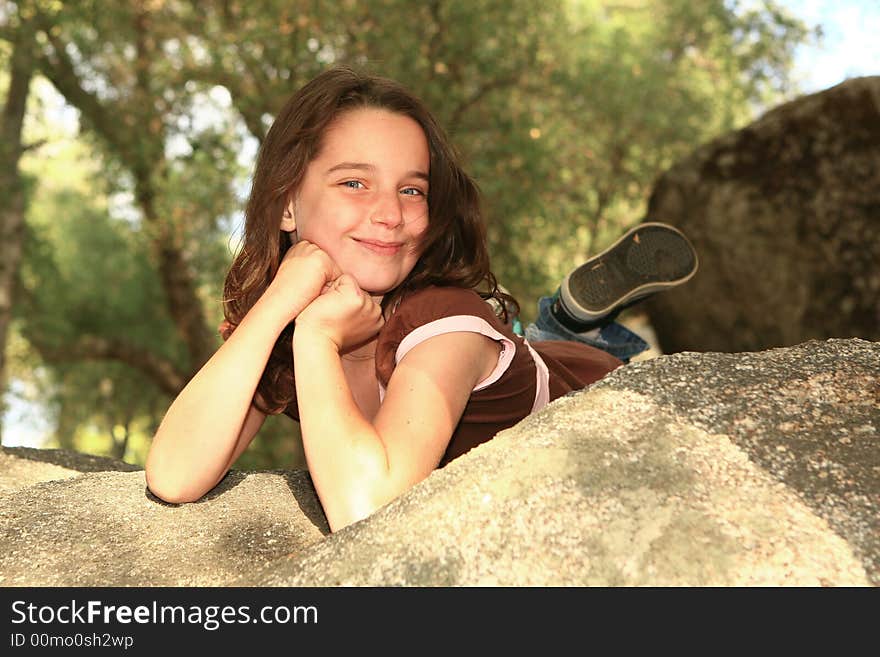 Beautiful Young Child Smiling Outdoors on a Rock. Beautiful Young Child Smiling Outdoors on a Rock