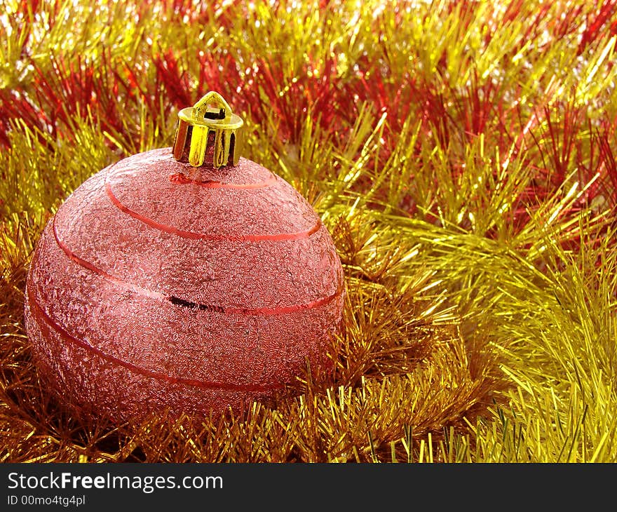 Red christmas bauble with golden tinsel