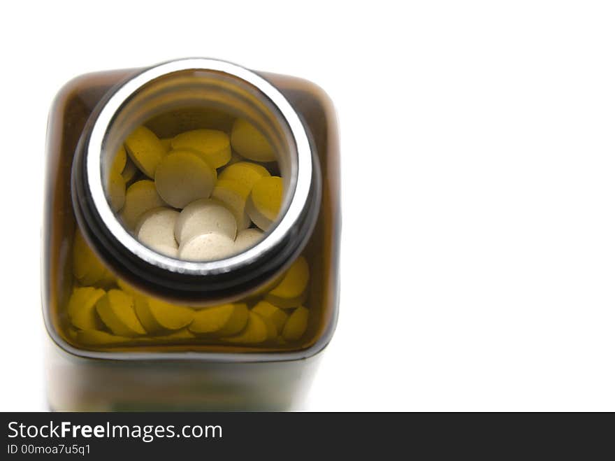 Upper view of a bottle full of white pills against white background. Upper view of a bottle full of white pills against white background