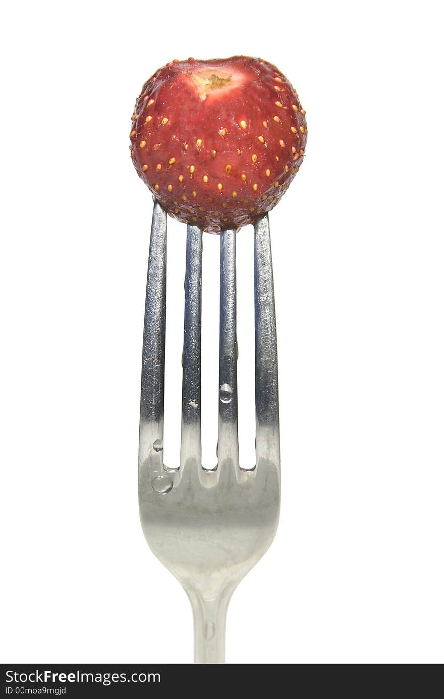 Close up of a red strawberry on a fork against white background. Close up of a red strawberry on a fork against white background