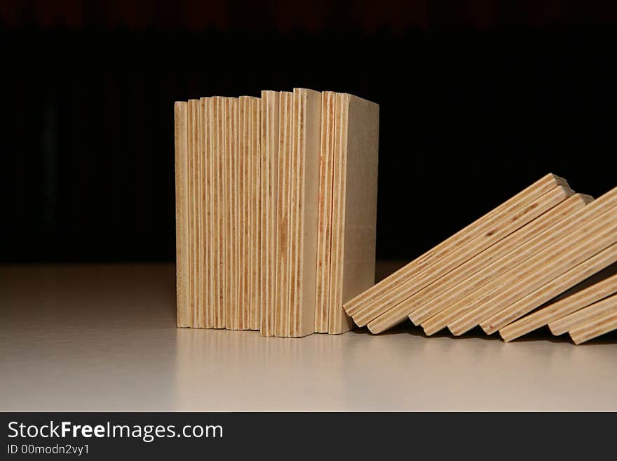 Fallen wooden domino blocks on black background.