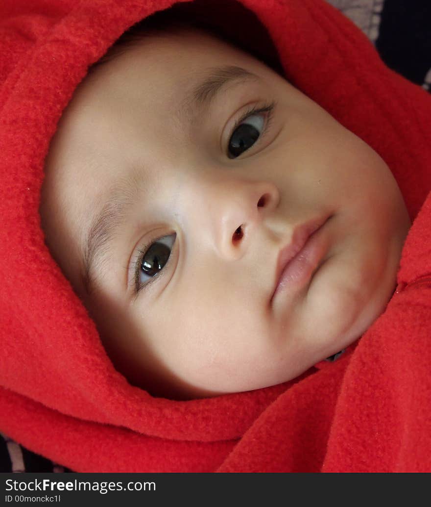 Six month old baby in red fleece hood. Six month old baby in red fleece hood