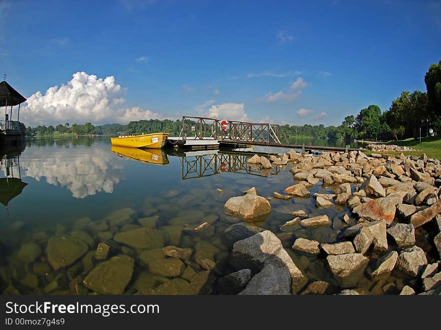 Yellow boat, skies and jetty