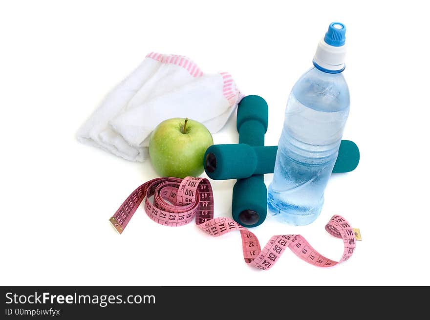 Dumbells, apple and measuring tape on a white background