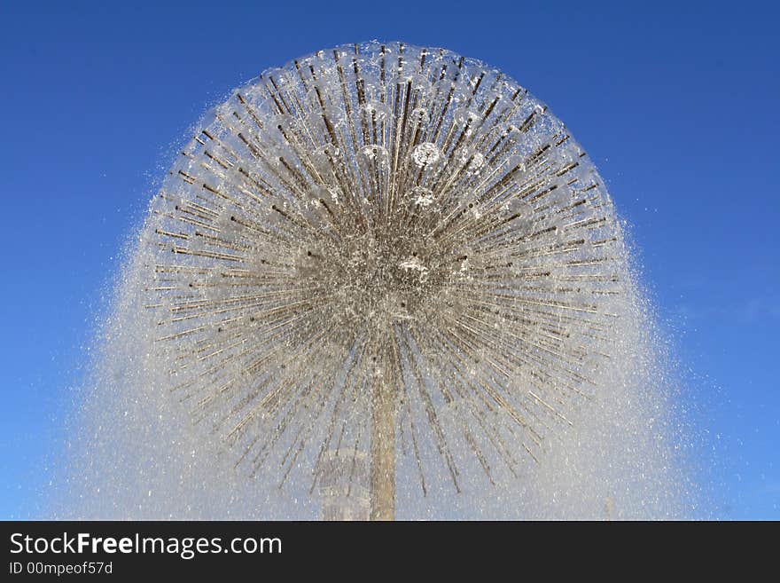 Water fountain on a background of the dark blue sky