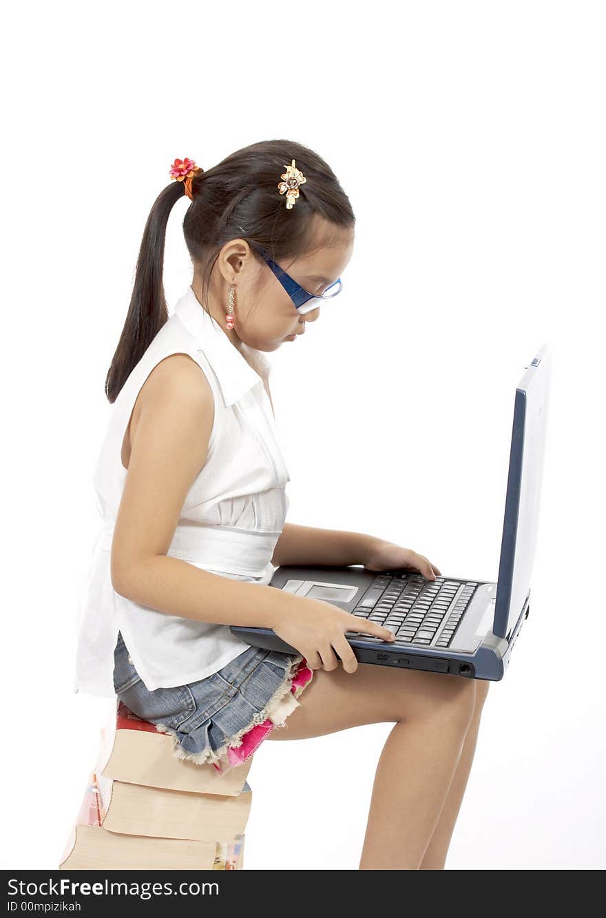 A young girl typing on a laptop. A young girl typing on a laptop