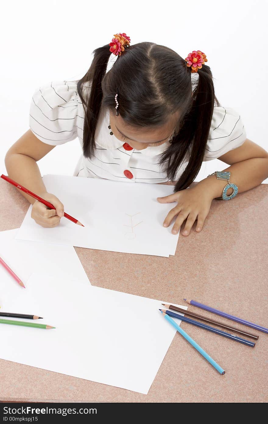 A young girl drawing on a white piece of paper