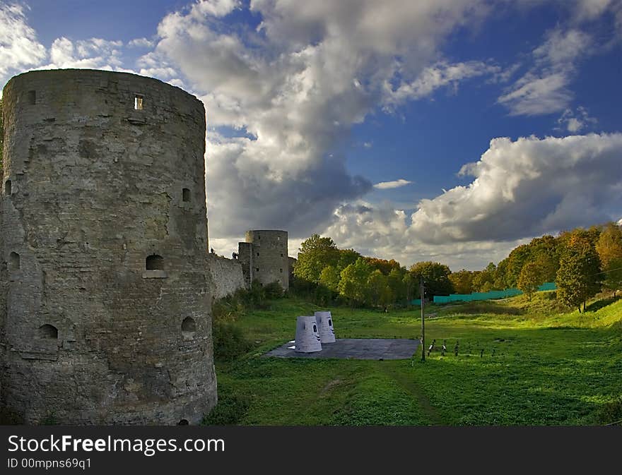 Medieval castle and green trees under blue sky with clouds. Medieval castle and green trees under blue sky with clouds