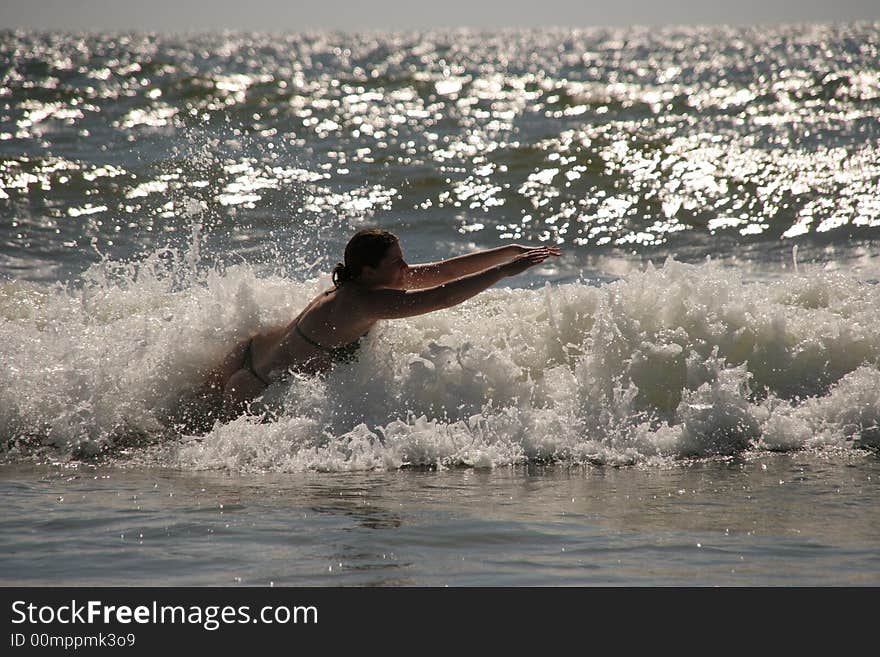 Silhouette of a wet young woman in a waving sea. Silhouette of a wet young woman in a waving sea