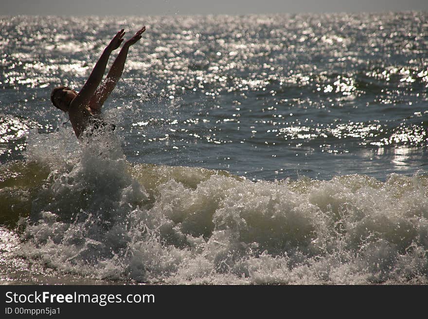 Silhouette of a wet young woman in a waving sea. Silhouette of a wet young woman in a waving sea