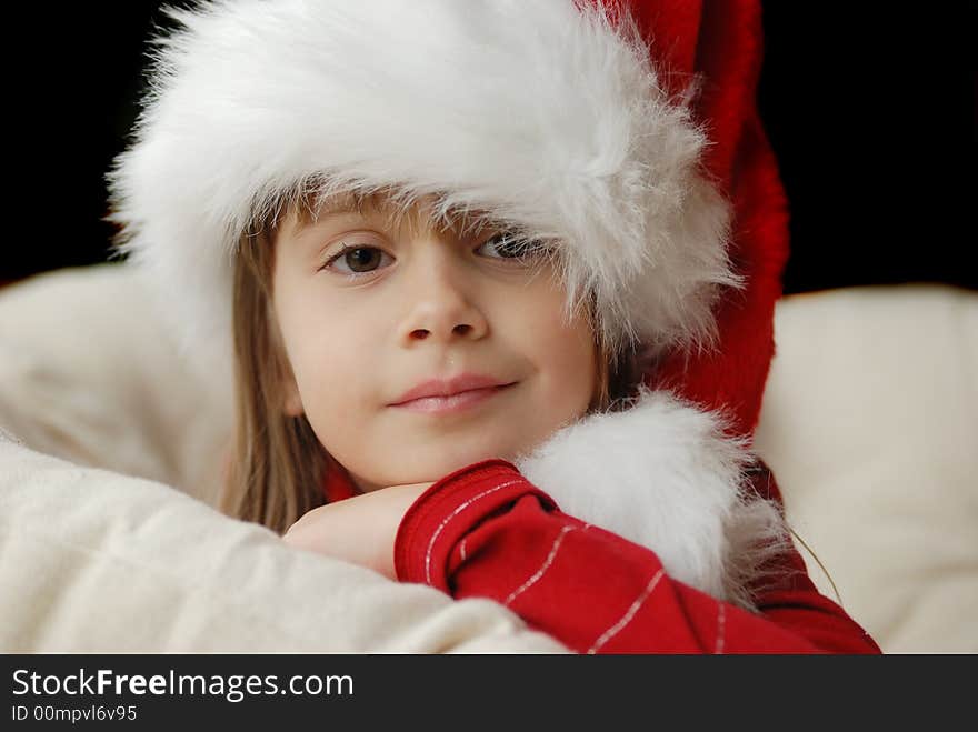 A beautiful young girl wearing a santa hat. A beautiful young girl wearing a santa hat