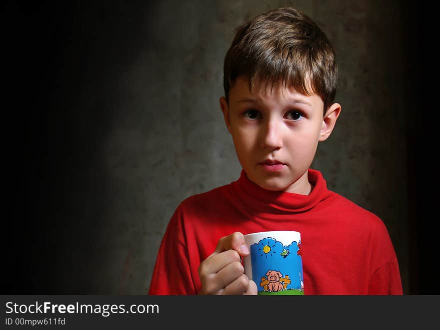 The little boy drinking a tea from color cup. The little boy drinking a tea from color cup