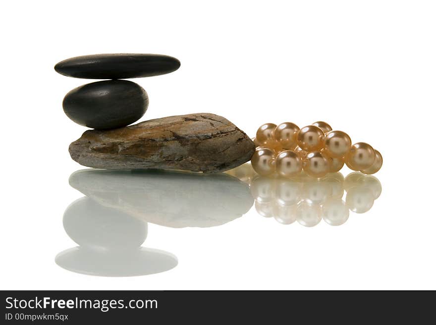 Pebble stone and pearl necklace over white background. Pebble stone and pearl necklace over white background