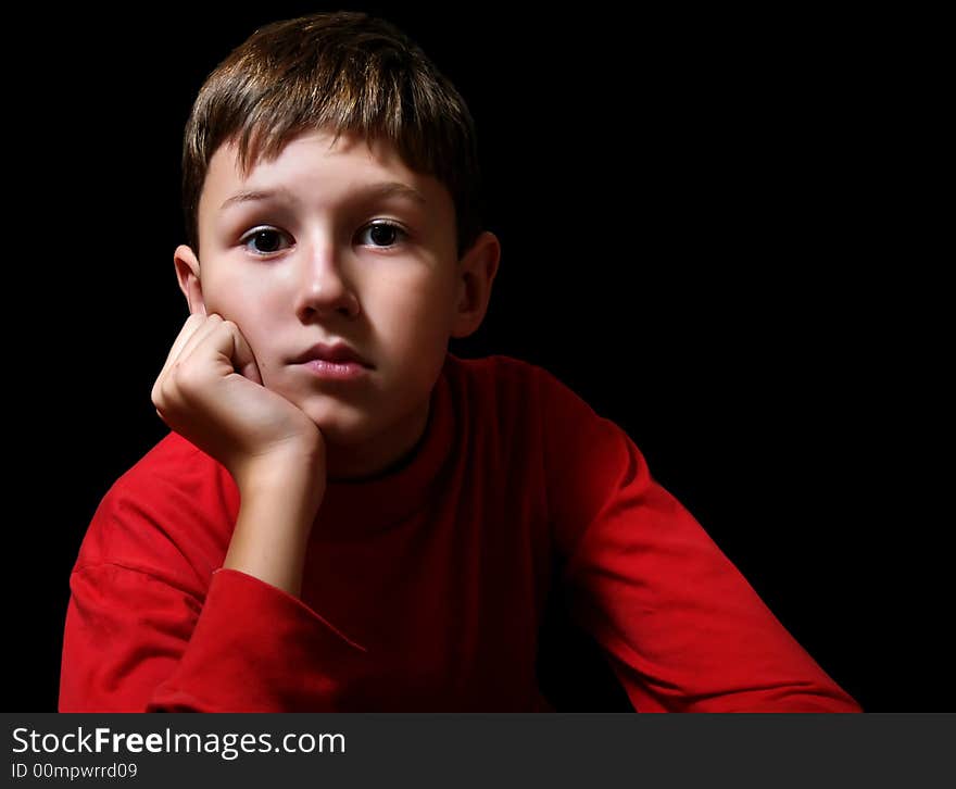 The thoughtful boy in a dark room