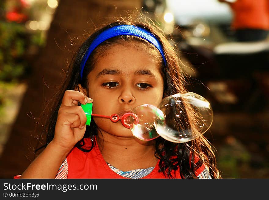 A girl releasing twin bubbles. A girl releasing twin bubbles.