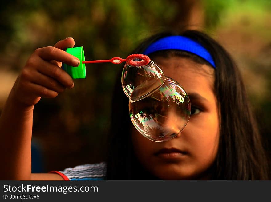 A girl holding twin bubbles. A girl holding twin bubbles.