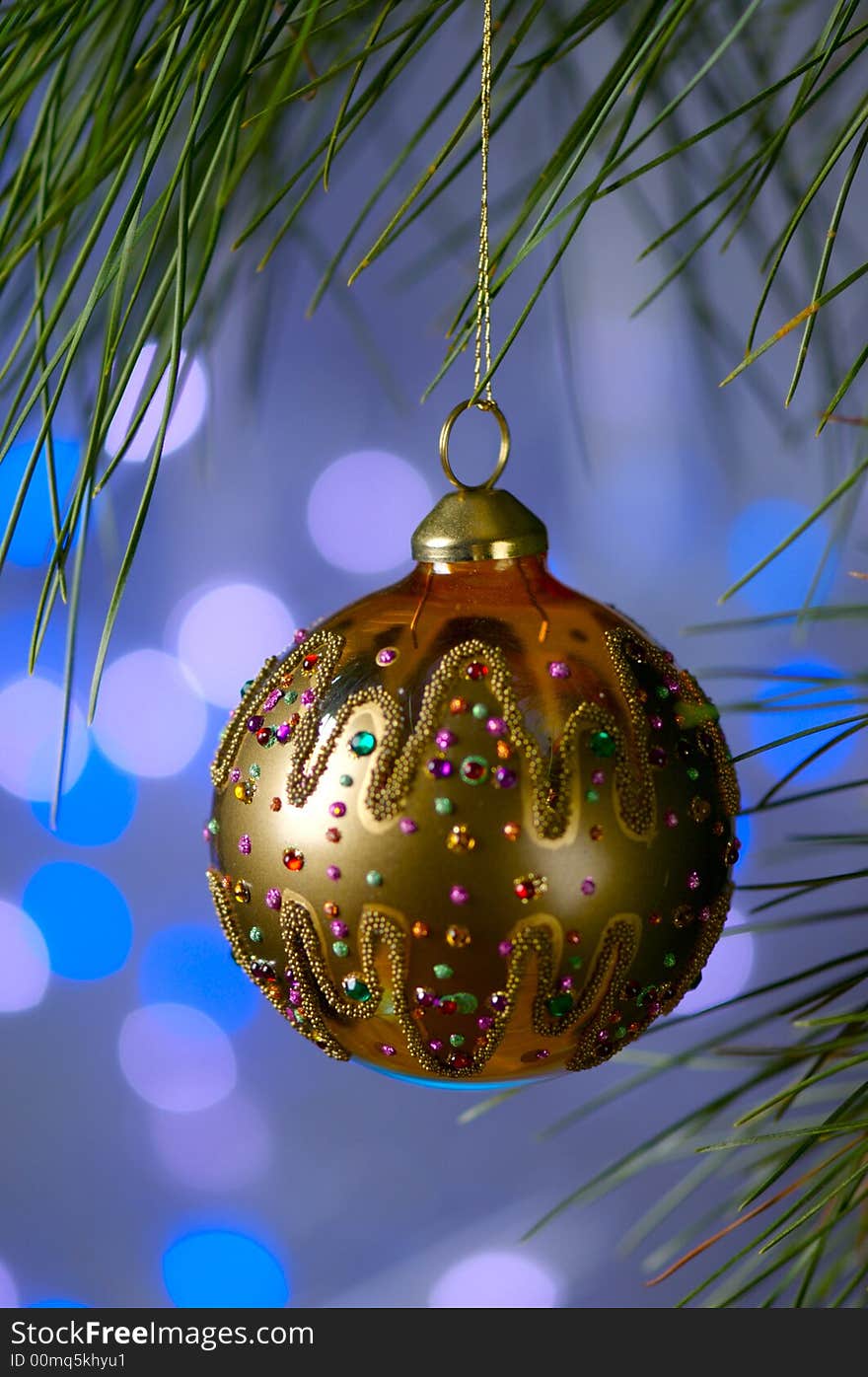 An image of a gold Christmas ornament on a blue background