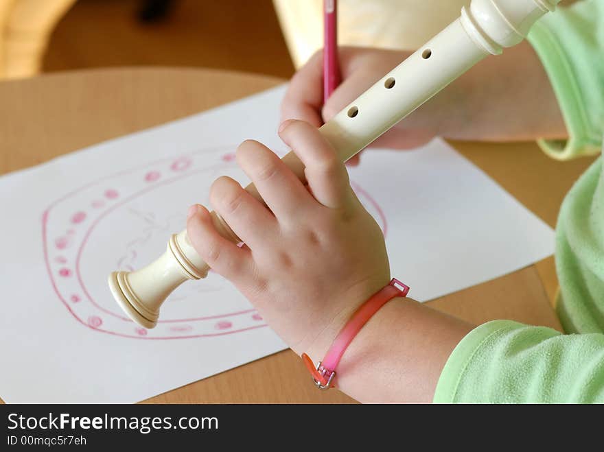 Little girl playing flue and drawing. Little girl playing flue and drawing