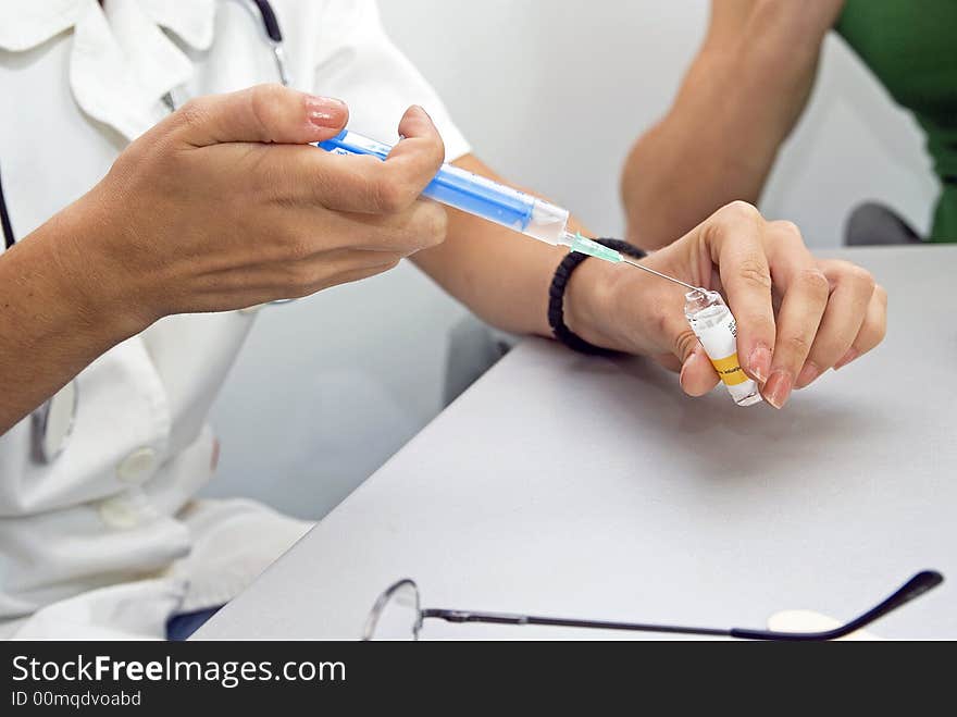 Young female doctor preparing injection