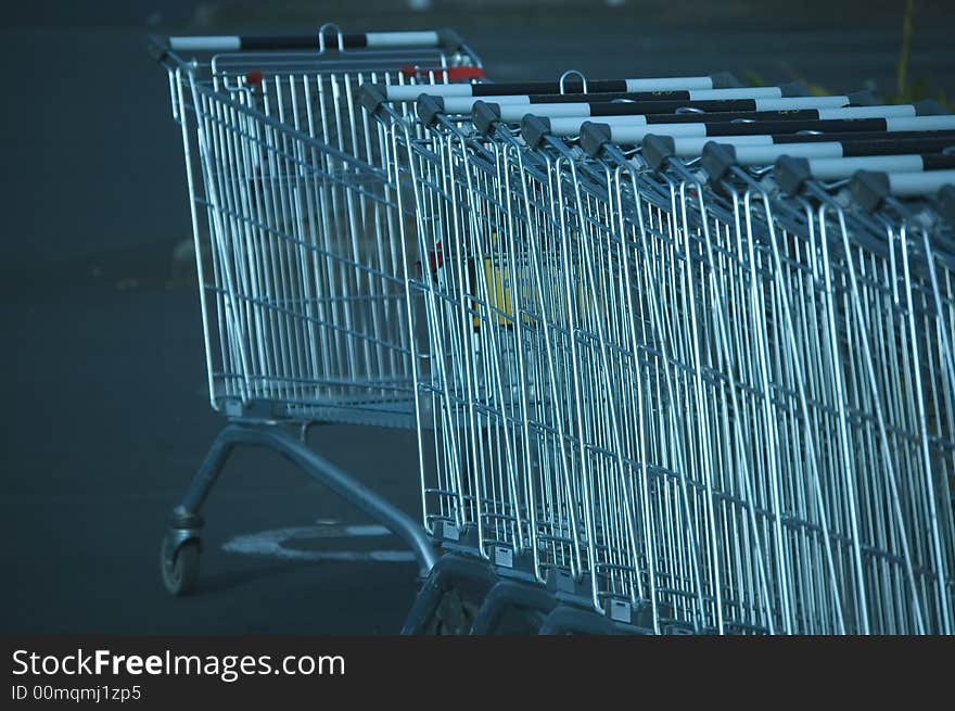 Stack of shopping trolleys at supermarket parking. Blue. Stack of shopping trolleys at supermarket parking. Blue